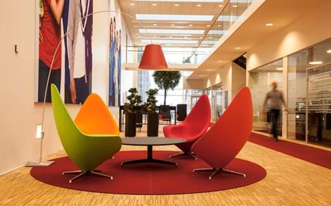 Runde, røde filttæpper i lounge område